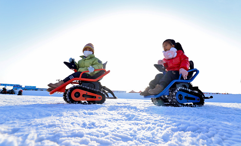 Children enjoy snowmobiling during a local ice and snow festival in Zhangye City, Gansu Province, January 13, 2024. /CFP