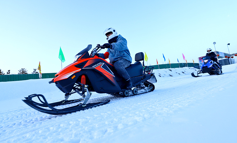 Visitors enjoy snowmobiling during a local ice and snow festival in Zhangye City, Gansu Province, January 13, 2024. /CFP