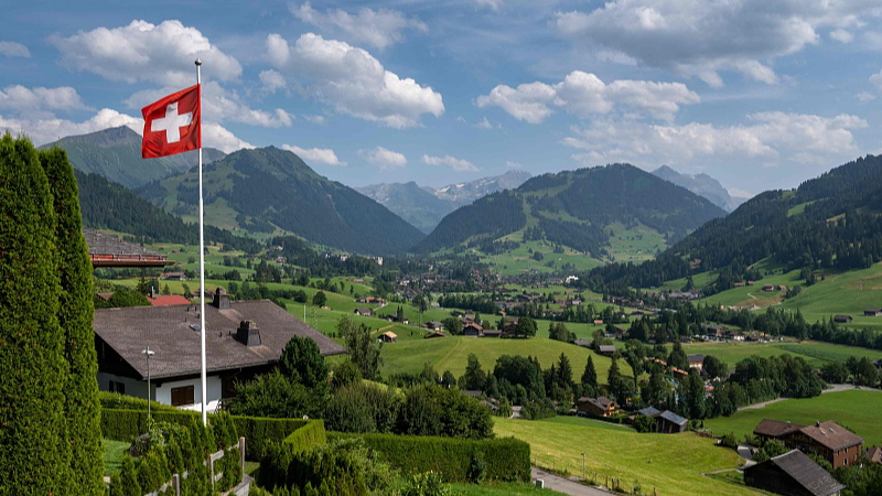 A Swiss flag and the Alps surrounding the resort of Gstaad in Saanen municipality, July 23, 2023. /CFP