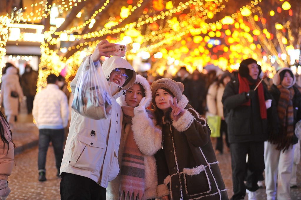 Visitors pose for selfies on Central Street in Harbin, capital of northeast China's Heilongjiang Province, December 31, 2023. /CFP