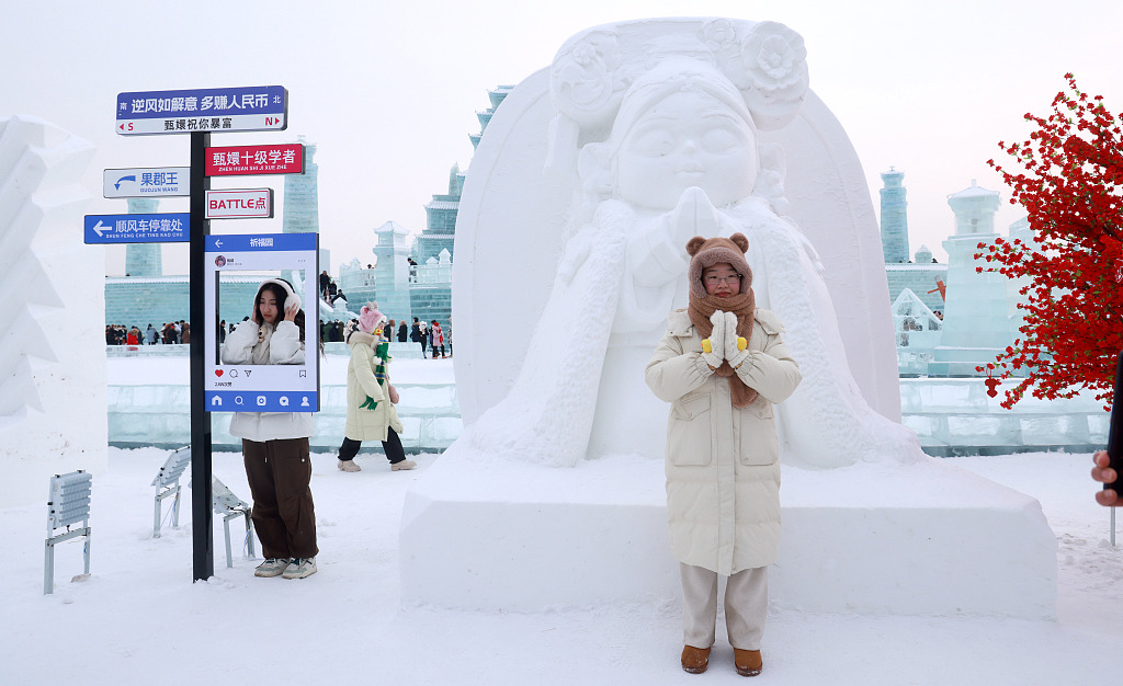 A visitor poses for a photo at a Chinese drama-inspired ice sculpture at the Harbin Ice and Snow World in Harbin, northeast China's Heilongjiang Province, January 10, 2024. /CFP