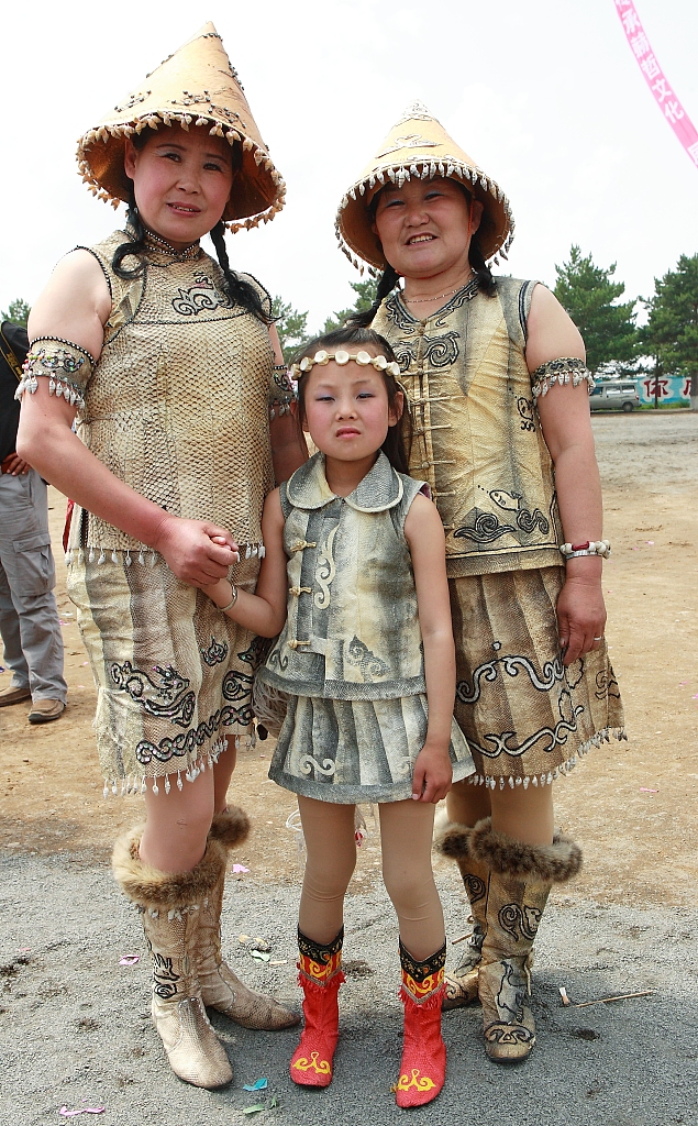 The Hezhe people dressed in traditional fish skin costumes. /CFP