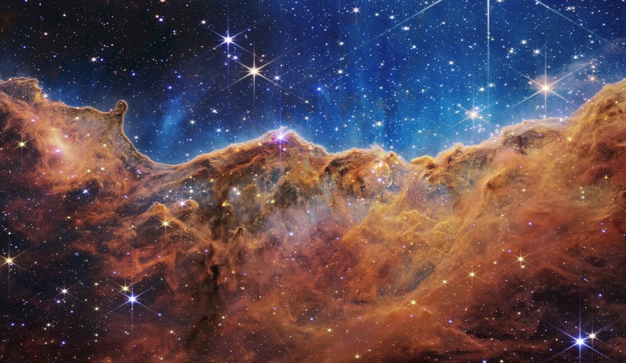 Image released by NASA on July 12, 2022 shows the edge of a nearby, young, star-forming region called NGC 3324 in the Carina Nebula. Captured in infrared light by NASA's James Webb Space Telescope, the image reveals for the first time previously invisible areas of star birth. /NASA via Xinhua