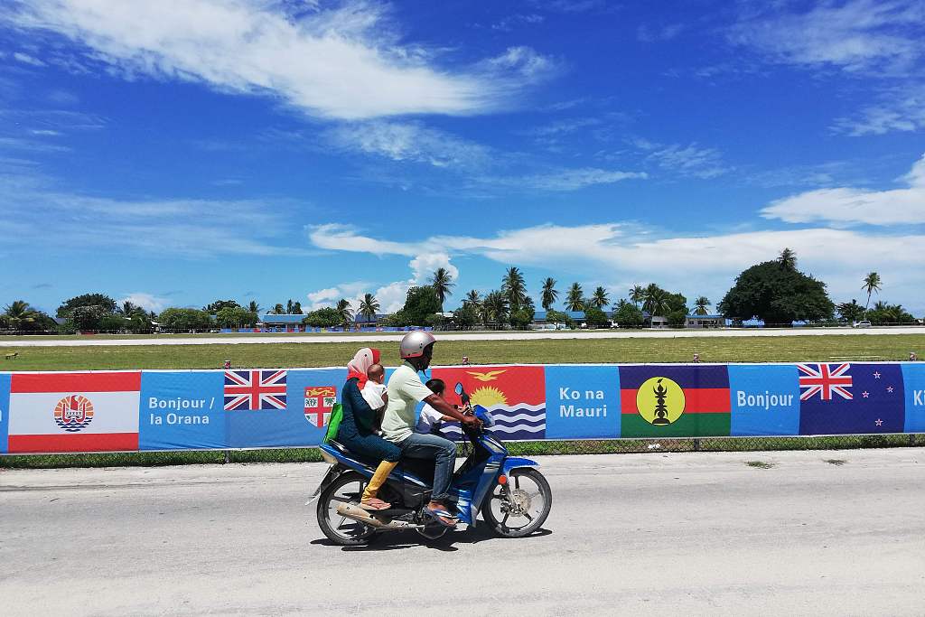 A motorbike rides past flags of Pacific Island countries on a road in Nauru, August 30, 2018. /CFP