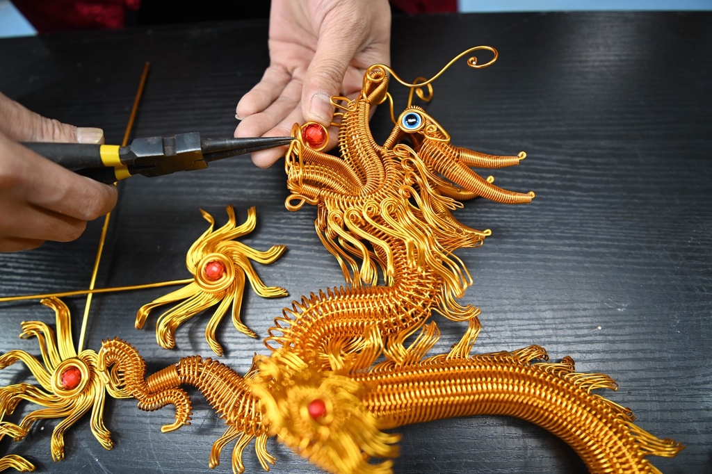 A photo shows a craftsman working on a wire loong at a workshop in Liaocheng, Shandong Province on January 15, 2024. /IC