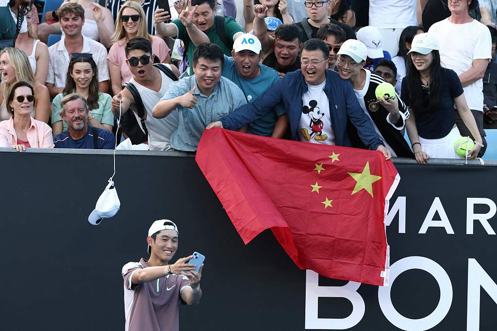 Shang Juncheng takes a selfie with fans after his win over Mackenzie McDonald in their men's singles match on day three of the Australian Open in Melbourne, Australia, January 16, 2024. /CFP