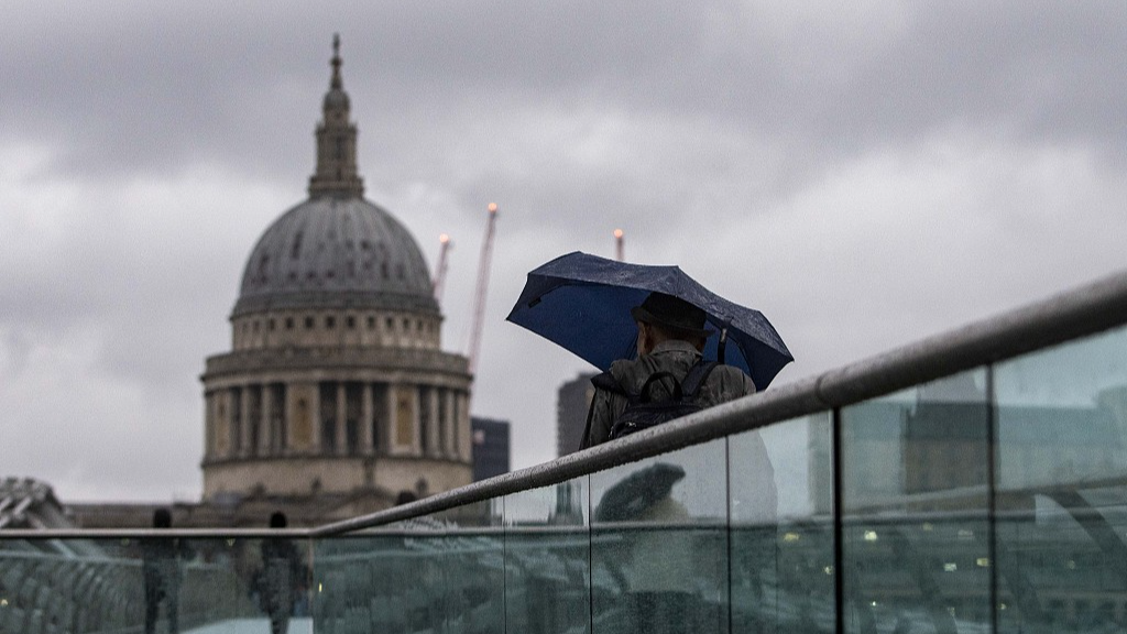 People brave the weather as they cross the Millennium Bridge in London, December 27, 2023. /CFP