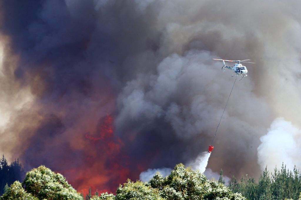 New Zealand Helicopters dump water to extinguish a blaze as 170 homes were evacuated from the area in the Tasman district February 7, 2019 in Richmond, near Nelson, New Zealand. /CFP