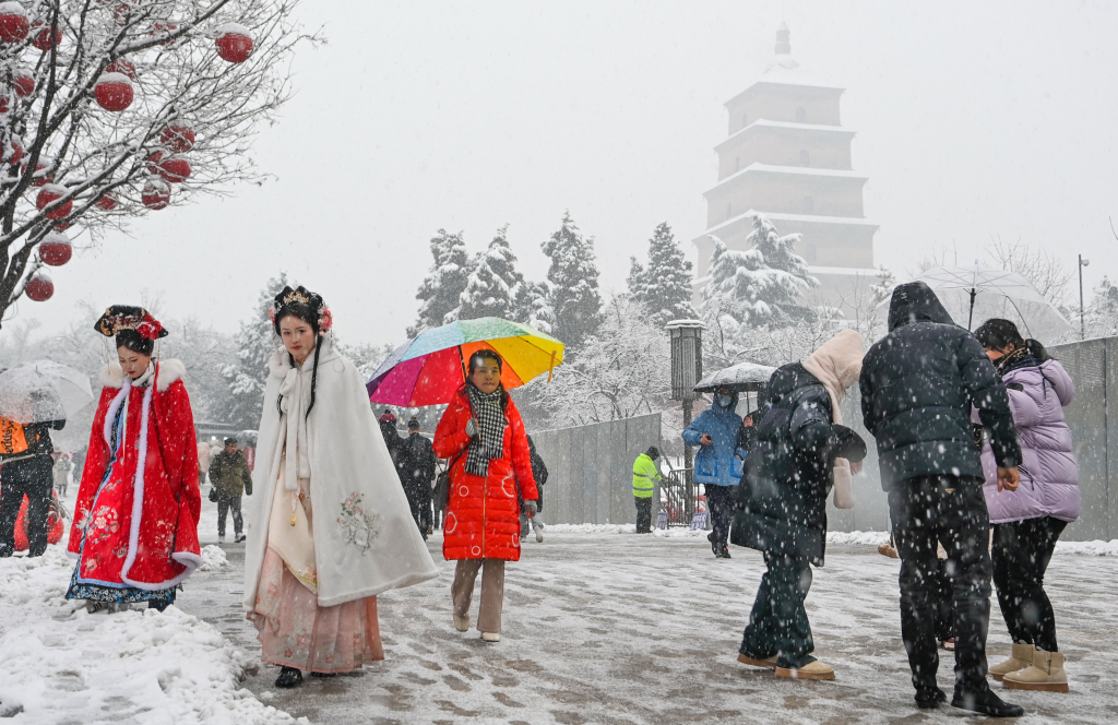 A photo shows people dressed in hanfu amid snowfall near the Dayan Pagoda in Xi'an, Shaanxi Province on January 16, 2024. /CFP