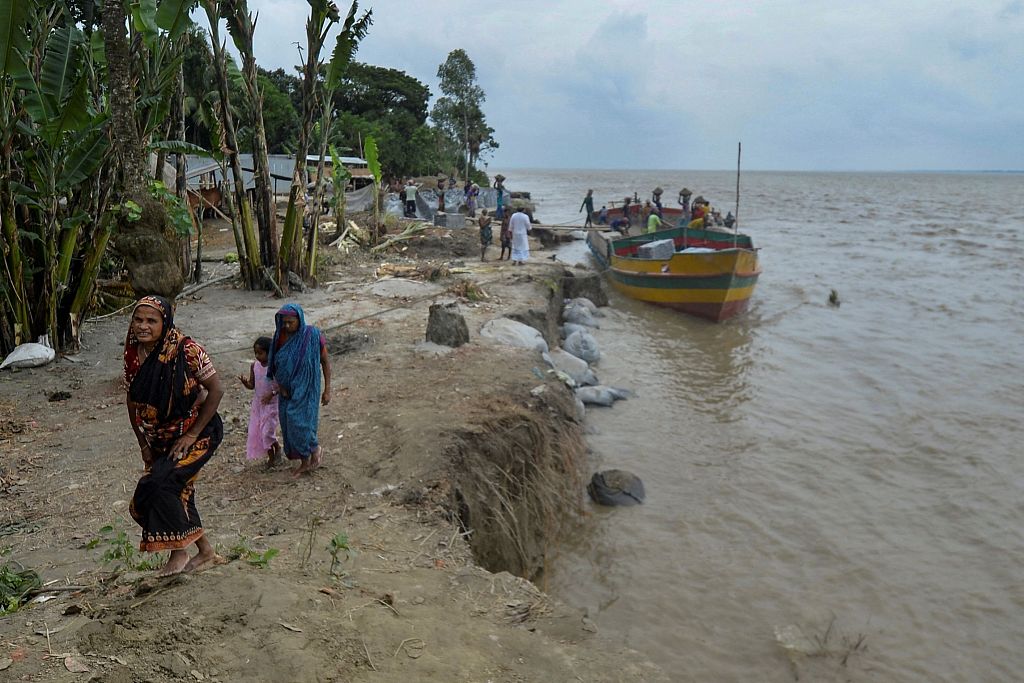 Locals walk past an eroded section on the banks of river Padma in Manikgonj, Bangladesh, September 20, 2021. /CFP