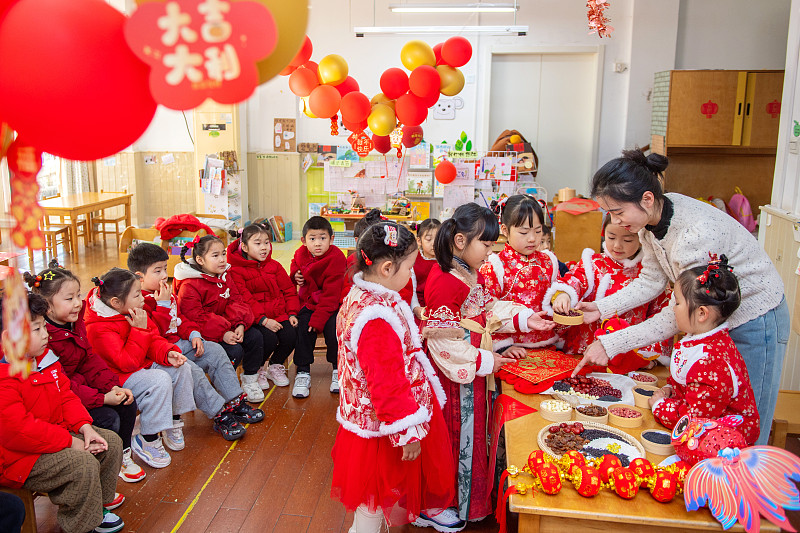 A teacher shows the ingredients used in Laba congee to children at a kindergarten in Huzhou, Zhejiang Province, January 17, 2024. /CFP