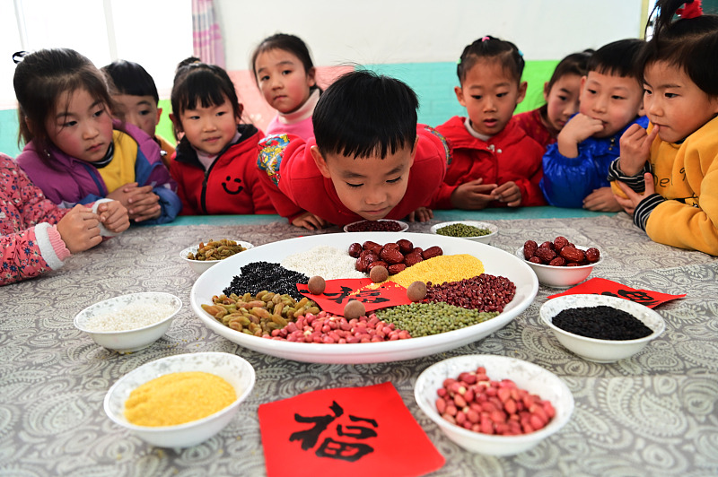 Children learn about the ingredients for making Laba congee in Liaocheng, Shandong Province, January 17, 2024. /CFP