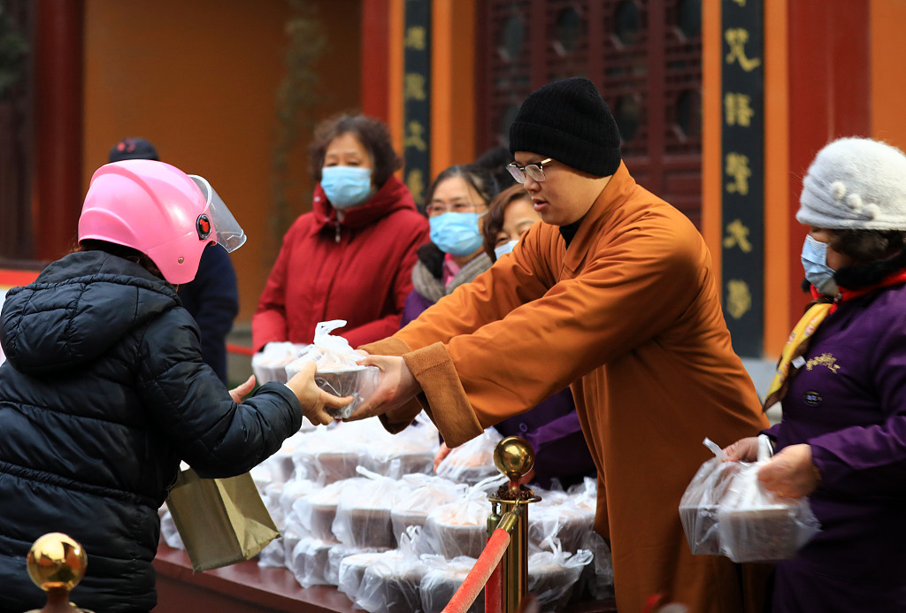 Visitors receive Laba congee from a monk at the Ciyun Temple in Huai'an City, Jiangsu Province on January 18, 2024. /CFP