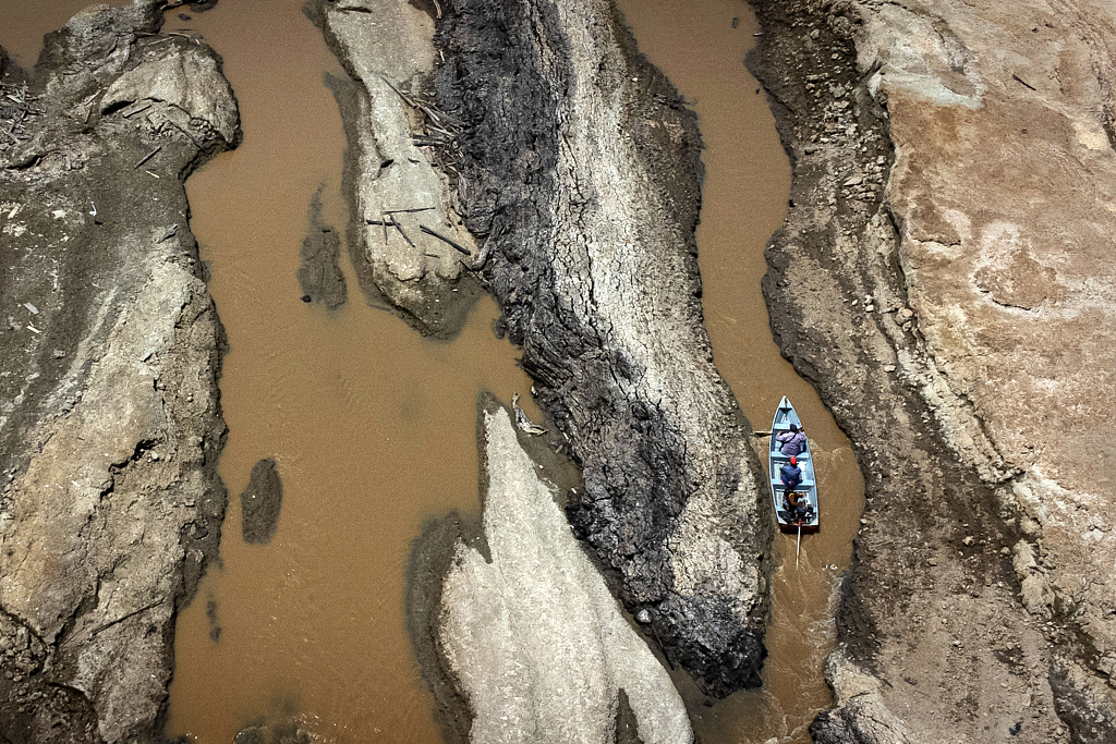 A small boat sails in the drought-hit rivers, at 