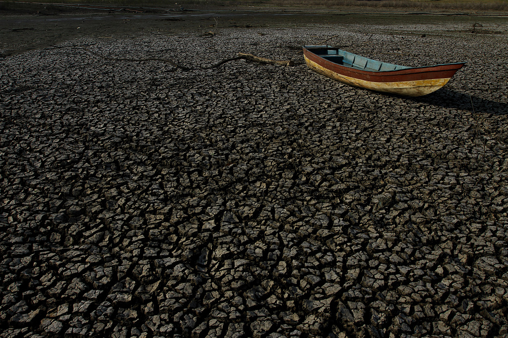 A fishing boat is seen stranded in the drying Gajah Mungkur Reservoir in Wuryantoro District, Indonesia, October 6, 2023. /CFP