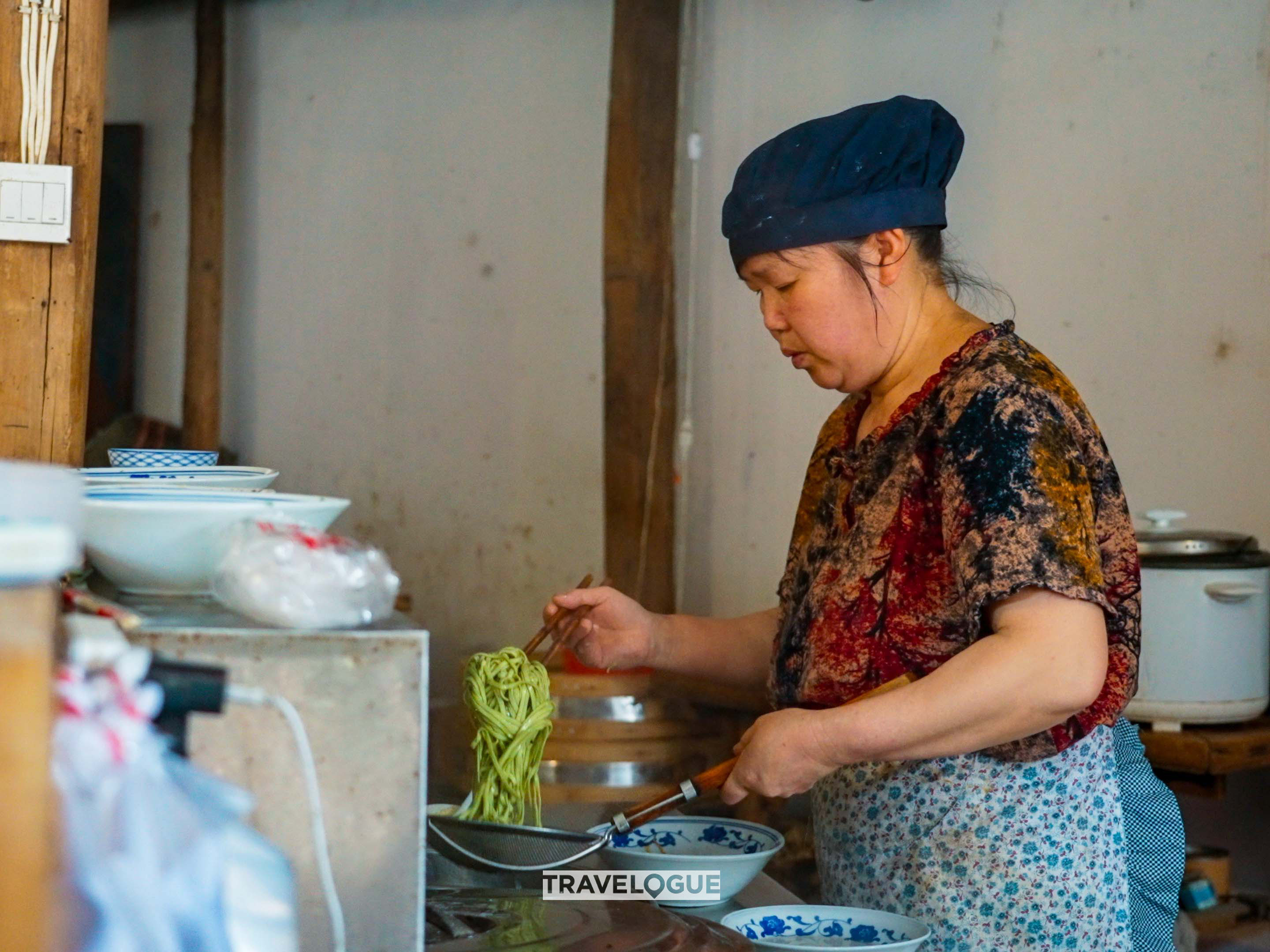 A woman makes green tea-infused noodles in Xiamei Village, Fujian. /CGTN