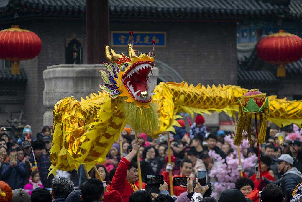 A file photo shows people gathered to see a dragon dance performance in Tianjin. /CFP