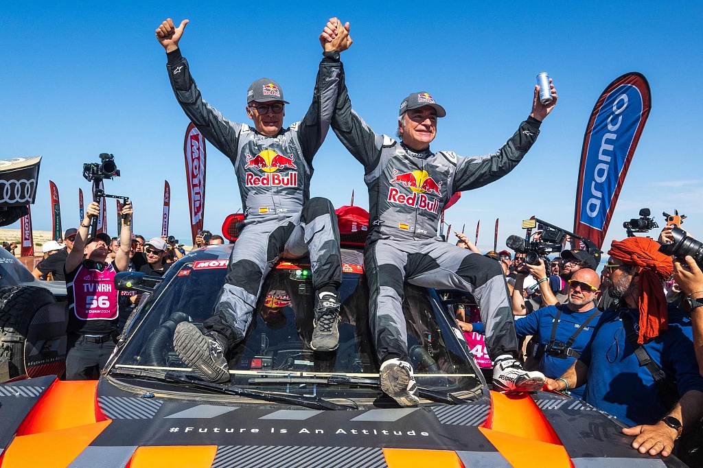 Spain's Carlos Sainz (R) and co-driver Lucas Cruz of Team Audi Sport celebrate their victory in the Dakar Rally in Yanbu, Saudi Arabia, January 19, 2024. /CFP