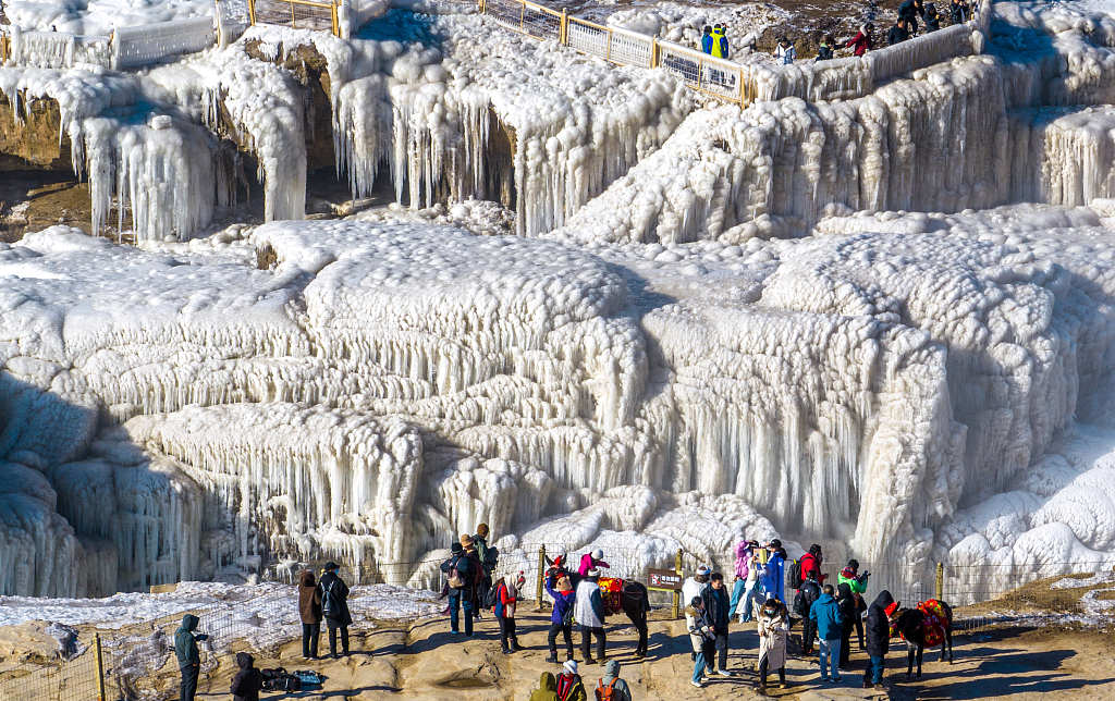 Visitors view the frozen Hukou Waterfall at a scenic area along the Yellow River in Linfen, Shanxi Province, on January 16, 2024. /CFP