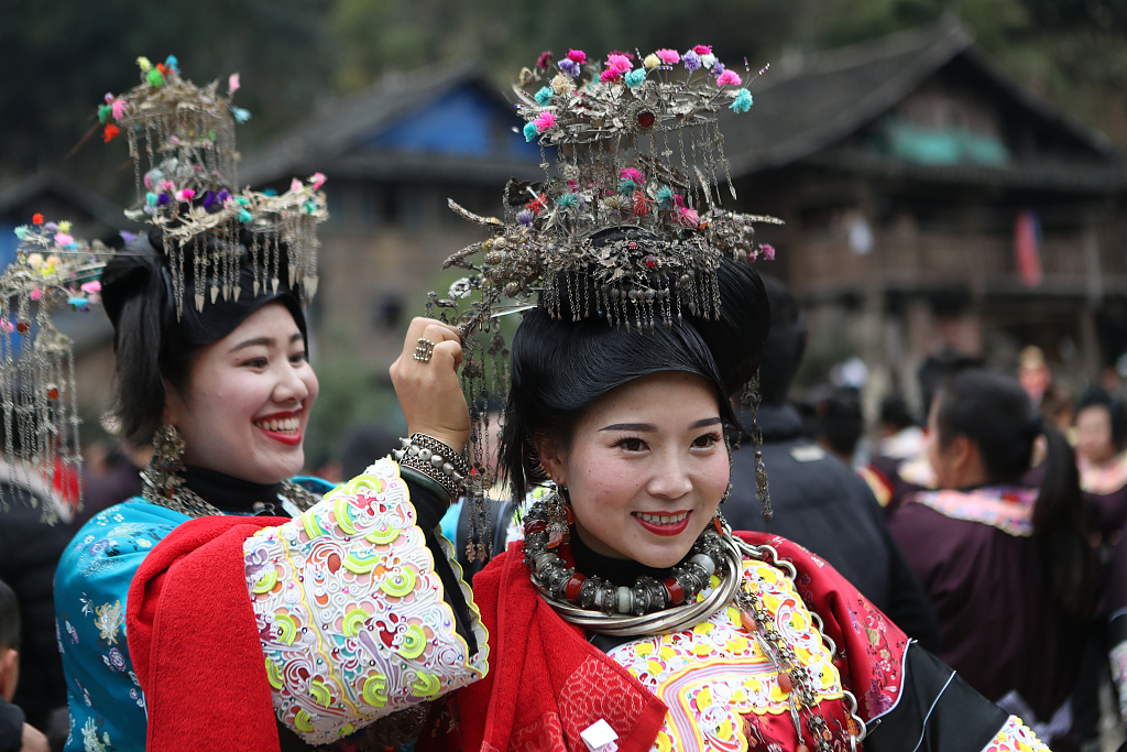 Two Dong girls dressed in beautiful attire help each other to arrange hair decoration pieces in Qiandongnan Miao and Dong Autonomous Prefecture, Guizhou Province, January 11, 2024. /CFP