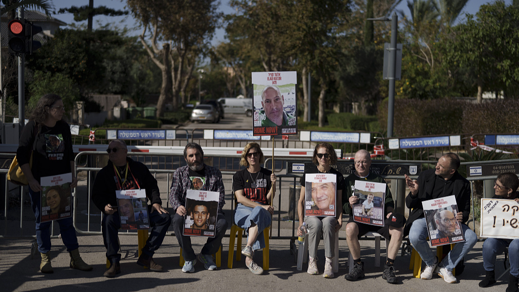 Relatives and friends of hostages sit on a street outside the private residence of the Israeli Prime Minister Benjamin Netanyahu, in Caesarea, Israel, January 20, 2024, in support of a father of an Israel hostage held in Gaza who has begun a hunger strike to protest the government's lack of visible progress on a new hostage deal. /CFP
