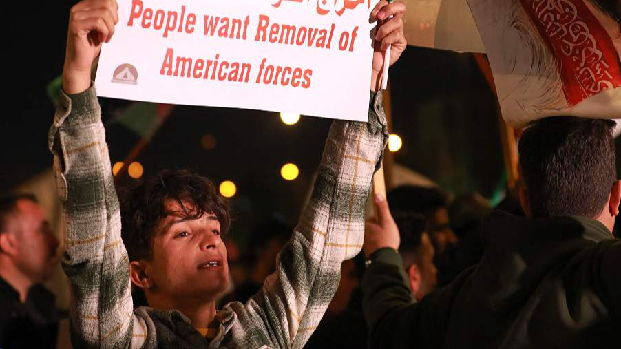 A supporter of pro-Iran factions raises a placard in Baghdad's Tahrir Square during a protest against the presence of U.S. forces in Iraq, January 13, 2024. /CFP