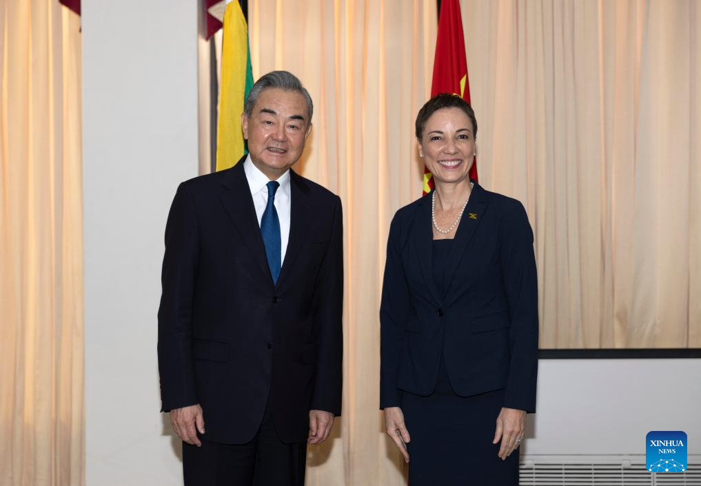 Chinese Foreign Minister Wang Yi, also a member of the Political Bureau of the Communist Party of China Central Committee, poses for photos with Jamaican Minister of Foreign Affairs and Foreign Trade Kamina Johnson Smith, in Kingston, Jamaica, January 20, 2024. /Xinhua