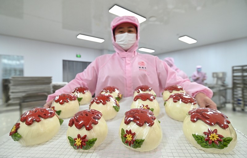 A worker displays huabobo at a bakery in Gaomi, Shandong Province, January 20, 2024. /CFP