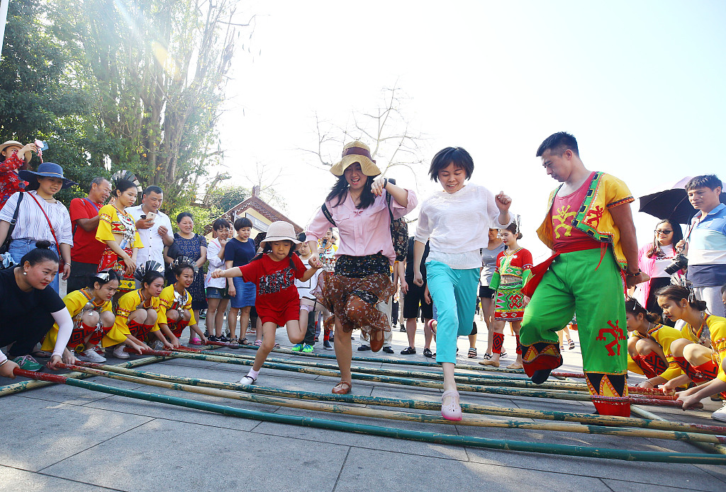 Tourists join in a Bamboo Dance with dancers of Li ethnic group at a Spring Festival temple fair in Sanya, Hainan Province, February 6, 2019. /CFP