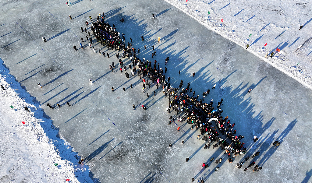 A drone's view of the tug of war on ice with people on opposing sides sitting on dragon boats in Harbin, China, January 14, 2024. /CFP 