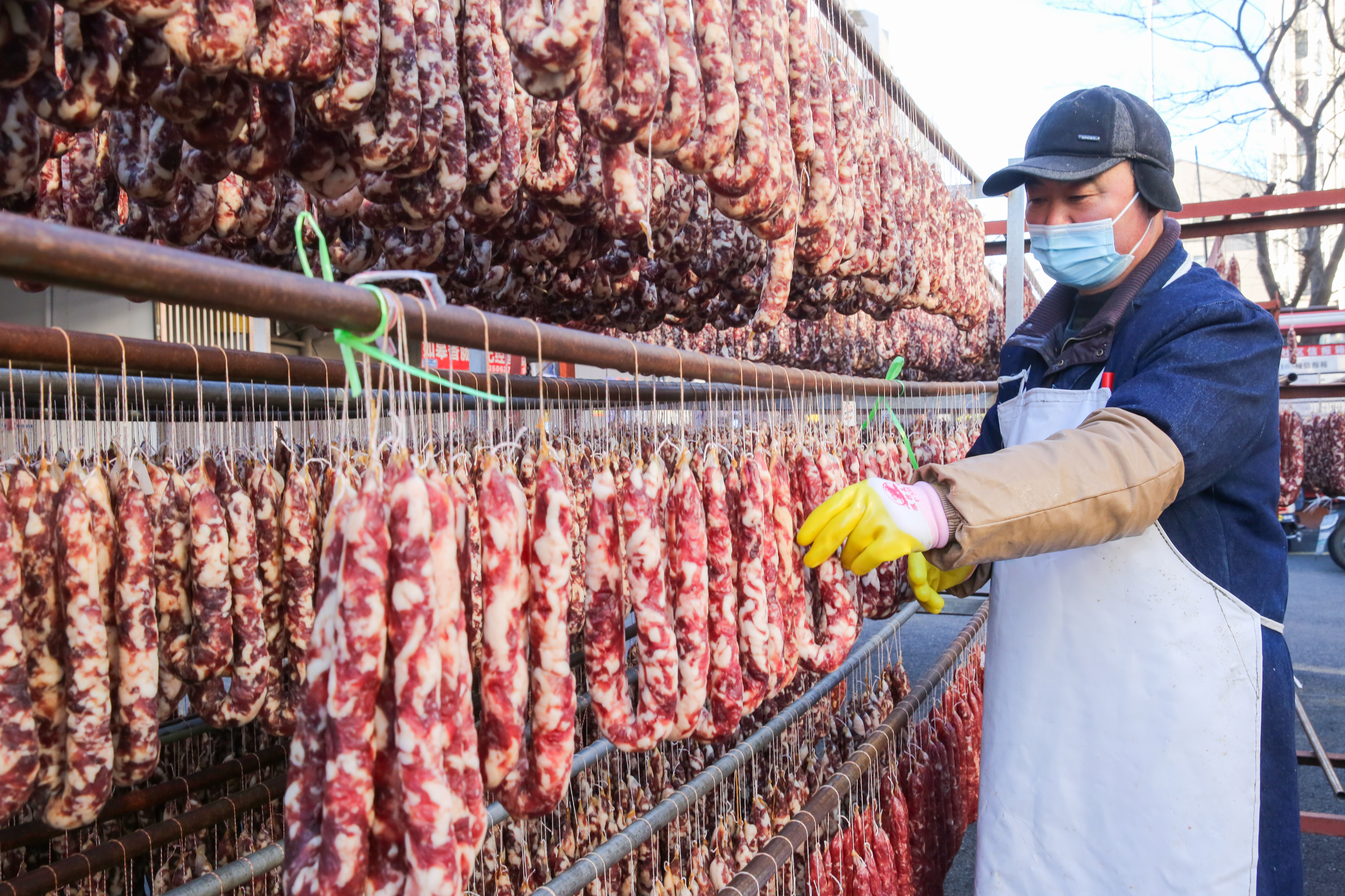 A worker is busy airing sausages at a yard in Rugao, Jiangsu Province, January 23, 2024. /IC