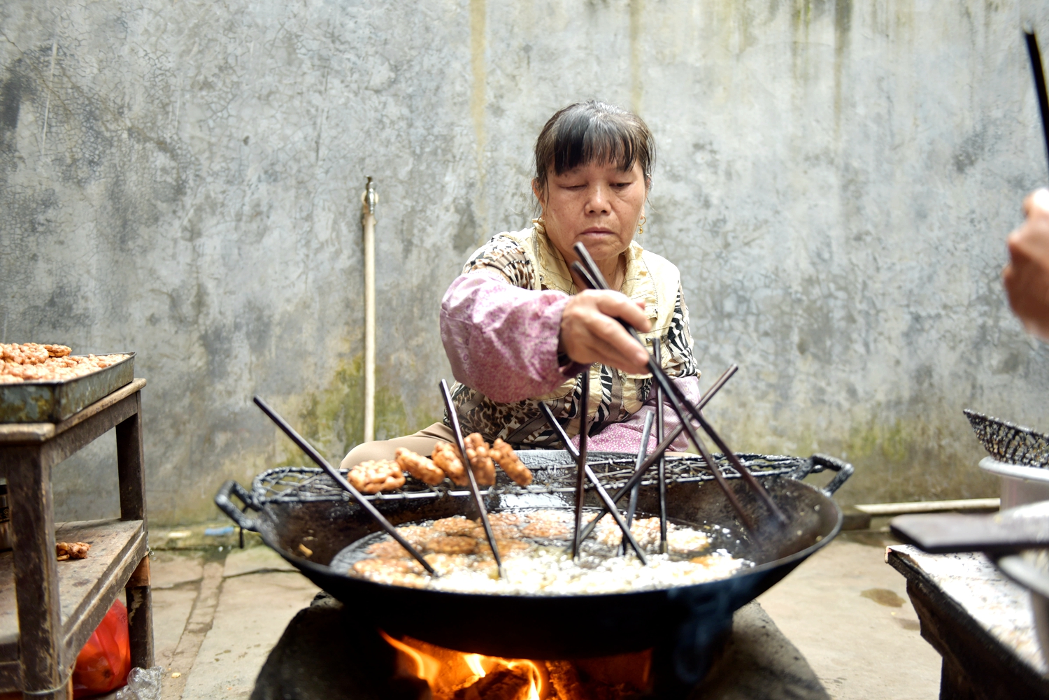 A local woman makes Wupo peanut cakes. /Photo provided to CGTN