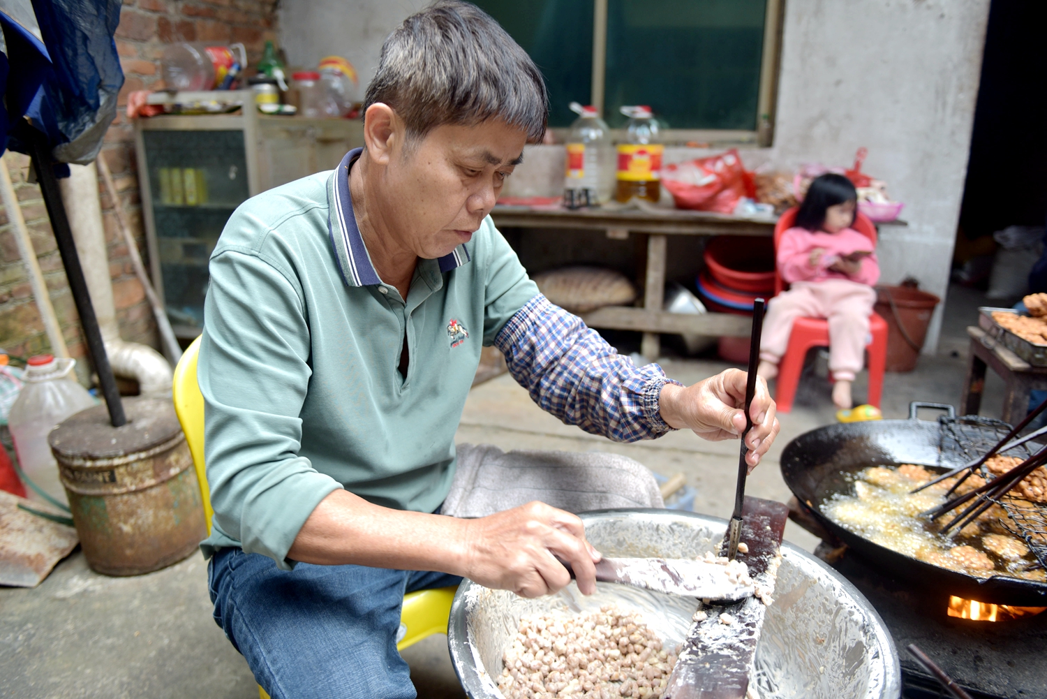 A local man makes Wupo peanut cakes. /Photo provided to CGTN