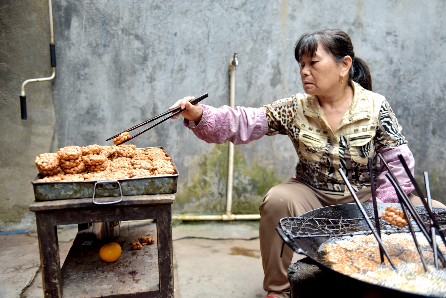 A local woman makes Wupo peanut cakes. /Photo provided to CGTN