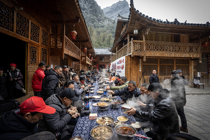 Visitors enjoy a feast with locals to celebrate New Year in Xuan'en County, Enshi Tujia and Miao Autonomous Prefecture, Hubei Province, January 24, 2024. /CFP