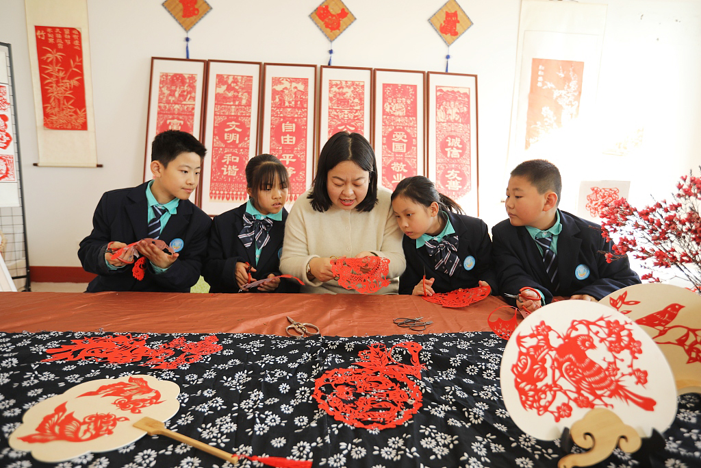 Ma Xiaomin, a teacher and papercutting inheritor, shows her students how to make Spring Festival-themed papercuts in Rizhao, Shandong Province on January 24, 2024. /CFP