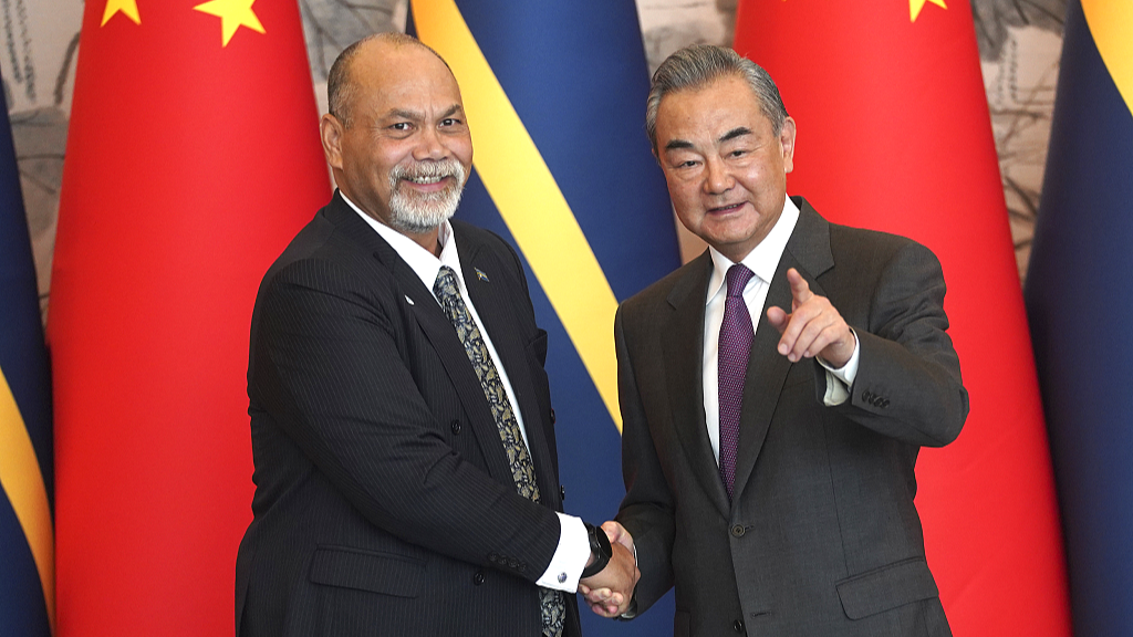 Chinese Foreign Minister Wang Yi (R) shakes hands with Nauru's Minister of Foreign Affairs and Trade Lionel Aingimea after they signed the Joint Communique on the Resumption of Diplomatic Relations between China and Nauru, at Diaoyutai State Guesthouse in Beijing, capital of China, January 24, 2024. /CFP
