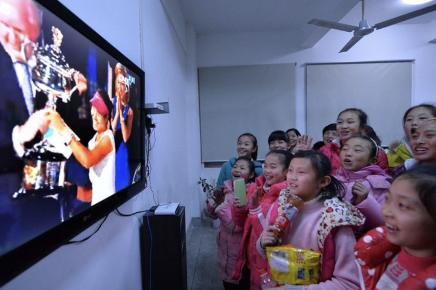Zheng Qinwen (R) watches the live broadcast of Li Na's Australian Open victory along with other kids in Wuhan, China, January 25, 2014. /CFP