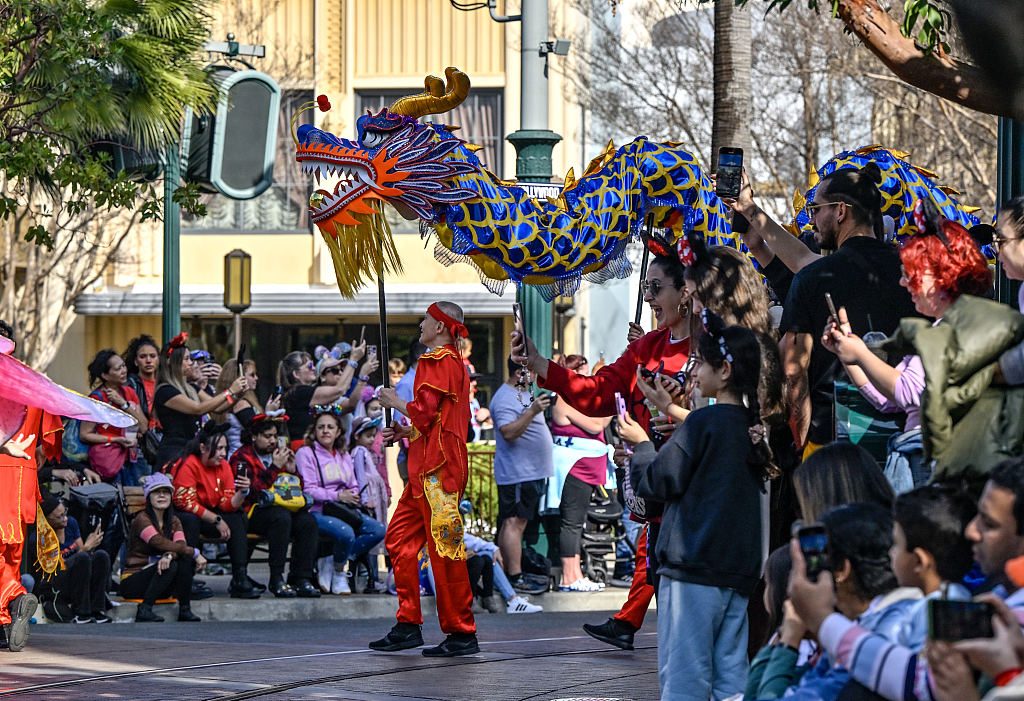 Tourists watch a dragon dance performance at Disney California Adventure on January 23, 2024. /CFP