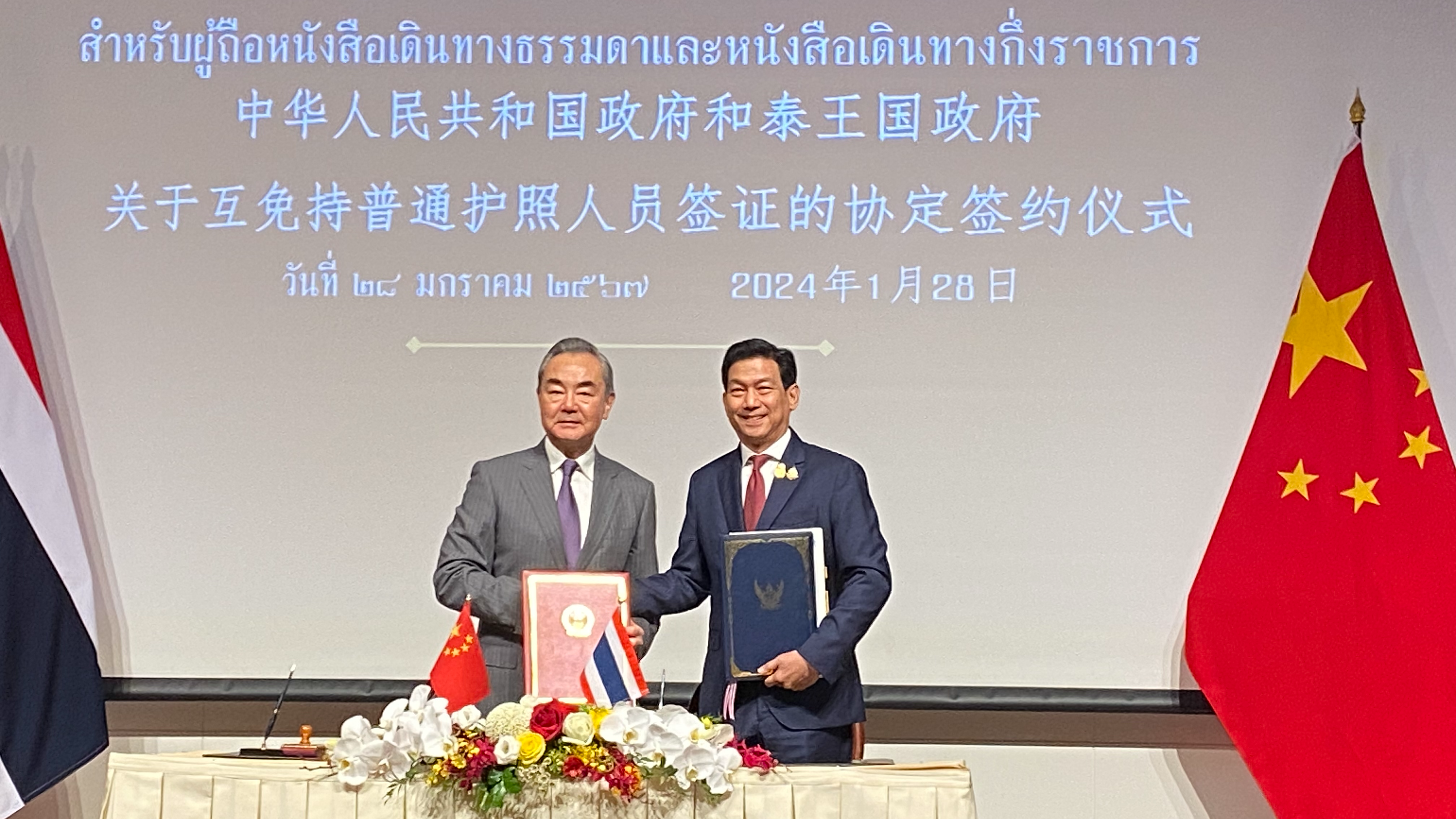 Chinese Foreign Minister Wang Yi (L) and his Thai counterpart Parnpree Bahiddha-Nukara at a signing ceremony of a mutual visa exemption agreement between China and Thailand in Bangkok, Thailand, January 28, 2024. /CGTN