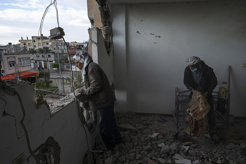 Palestinians collect their belongings from their damaged house after an Israeli airstrike in Rafah, southern Gaza Strip, January 27, 2024. /CFP