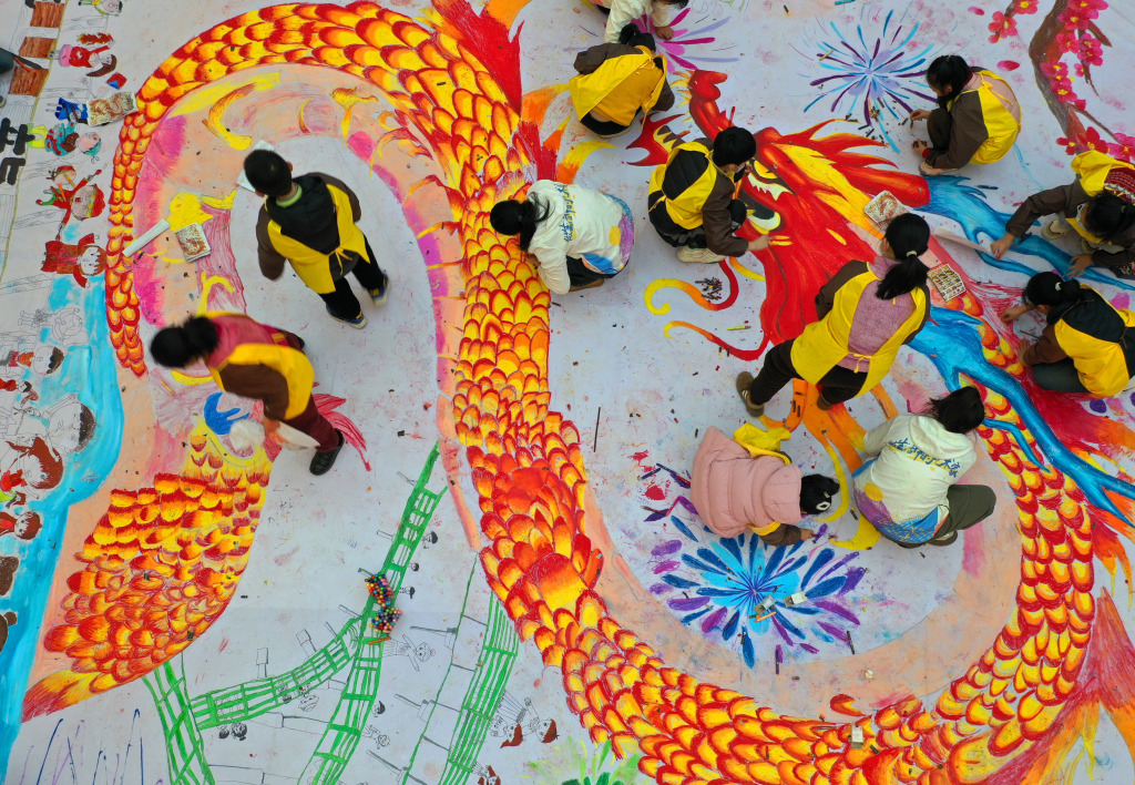 Children work together to color in a Chinese dragon-themed painting in Xuzhou, Jiangsu Province, January 27, 2024. /CFP
