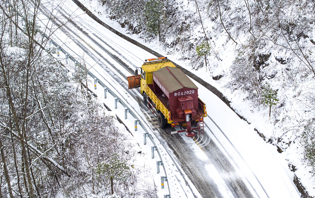 Snow plows sprinkle salt on a road to clear the snow in Nanchuan District, southwest China's Chongqing Municipality, January 22, 2024. /CFP