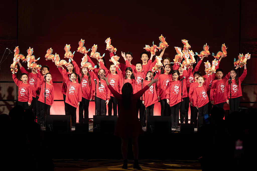 A children's chorus stages a performance of the Chinese song 