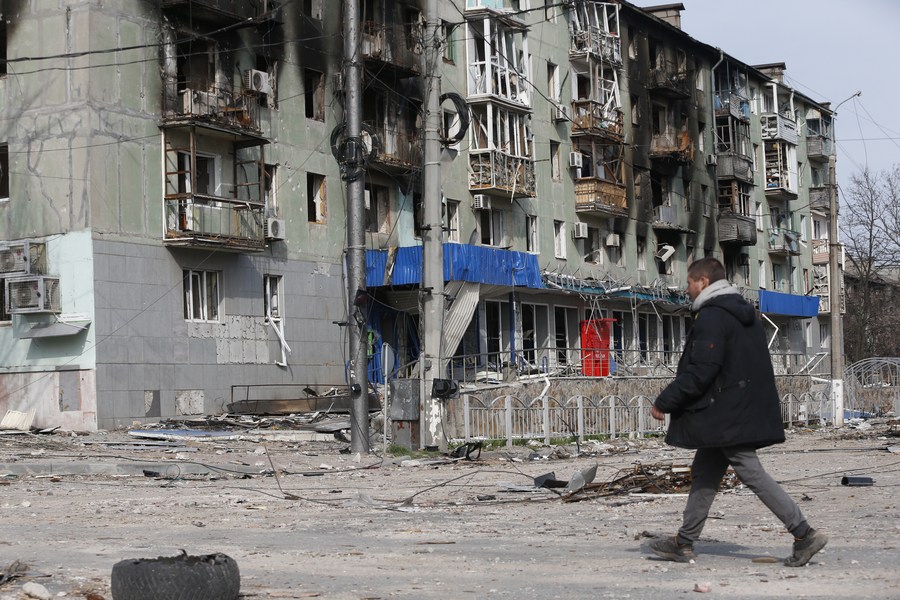 A man walks near a residential building damaged in Mariupol, Ukraine, April 17, 2022. /Xinhua