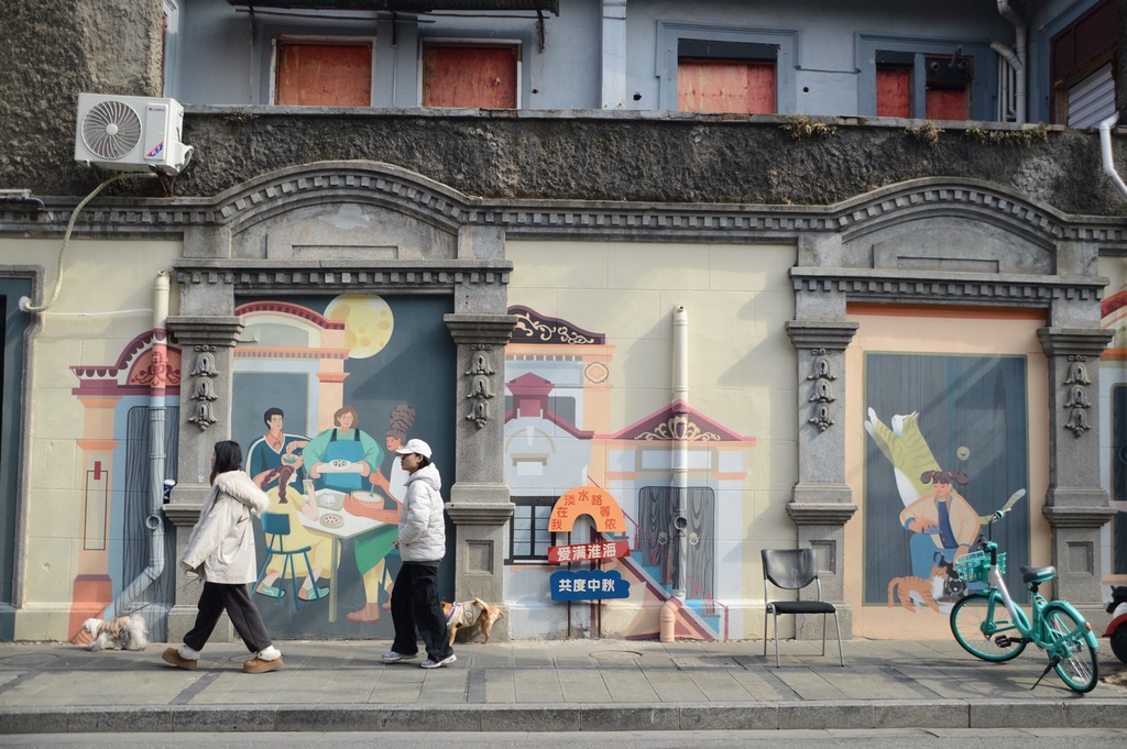 A photo taken on January 26, 2024 shows a mural on a Shikumen building in Shanghai depicting people's lives in the city. /IC