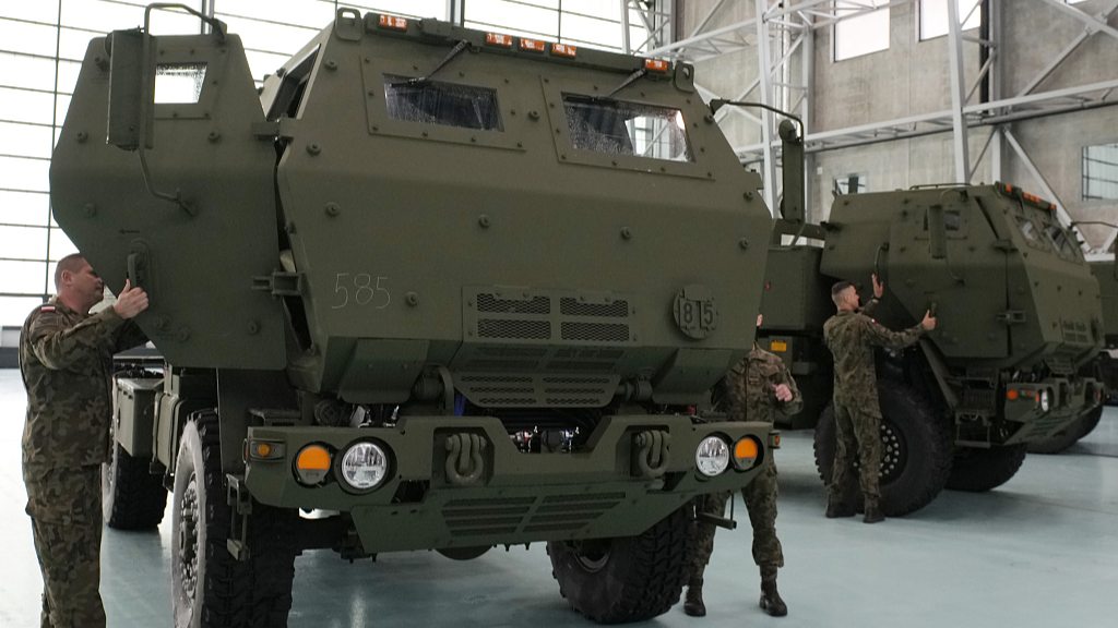 Polish soldiers look at a vehicle carrying one of the U.S.-made HIMARS rocket launchers at an air base in Warsaw, Poland, 15 May 2023. /CFP