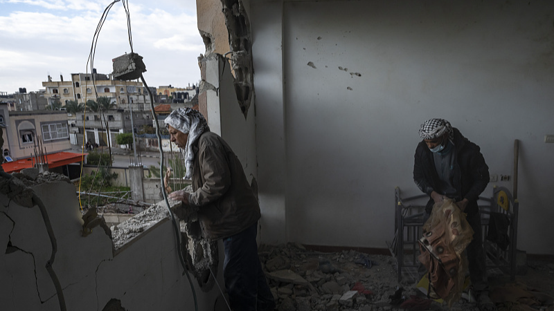 Palestinians collect their belongings from their damaged house after an Israeli airstrike in Rafah, southern Gaza Strip, January 27, 2024. /CFP