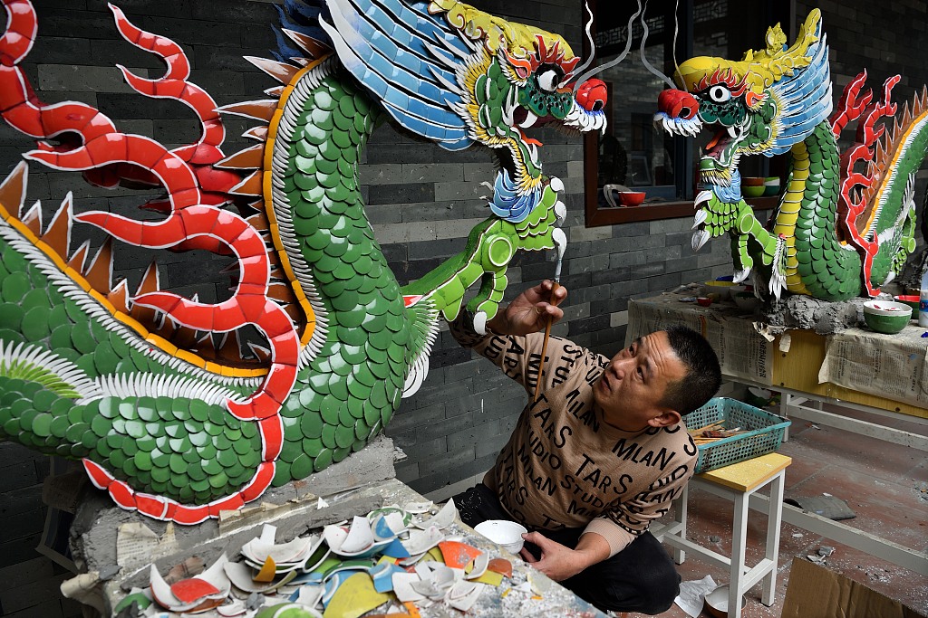 A photo shows artisan Lu Bo painting an inlaid porcelain dragon in Chaozhou, Guangdong Province, on January 29, 2024. /CFP