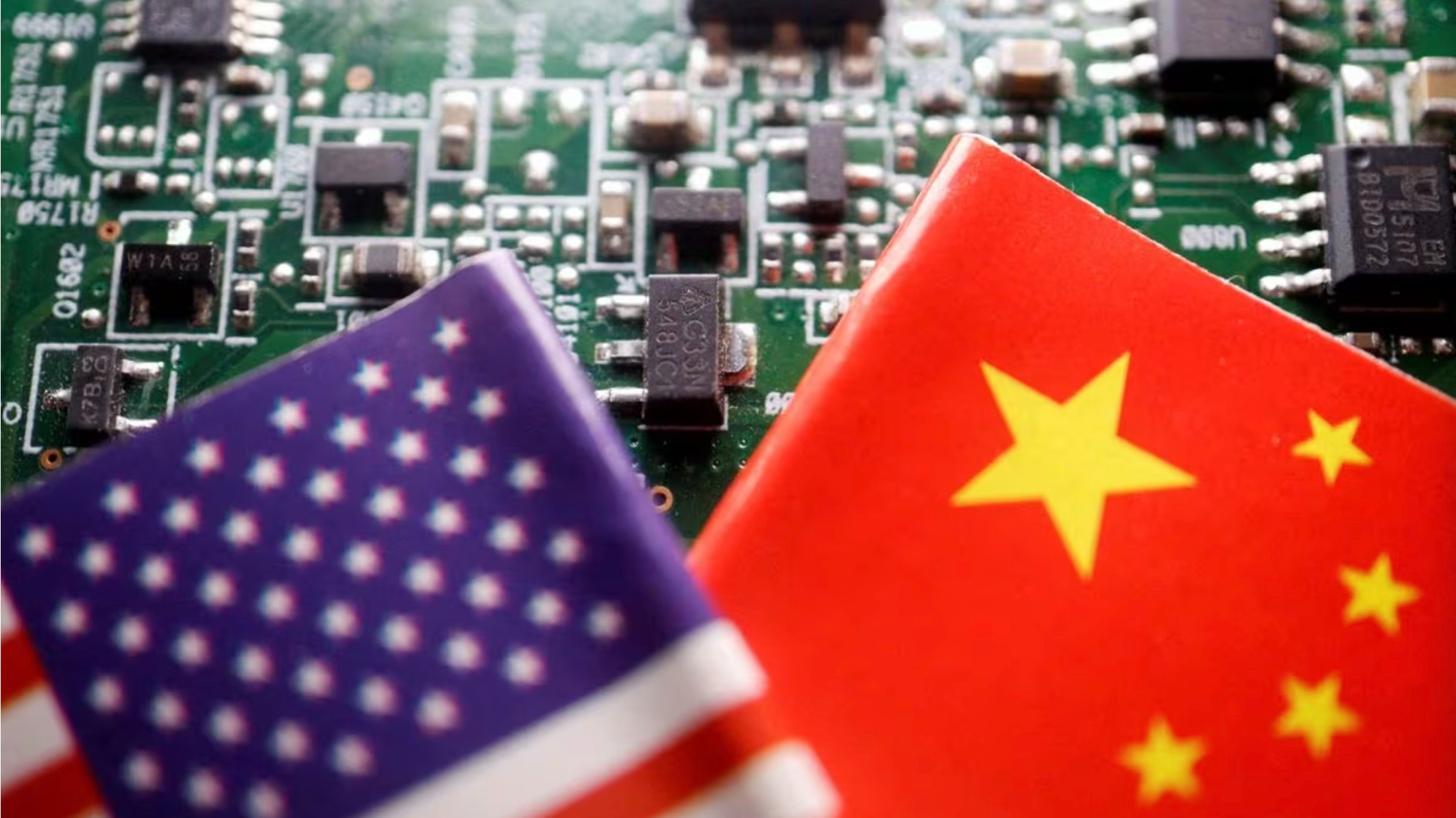 An illustration shows the national flags of China and U.S. displayed on a printed circuit board with semiconductor chips. /Reuters